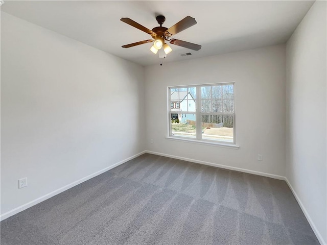 unfurnished room with visible vents, baseboards, a ceiling fan, and dark carpet