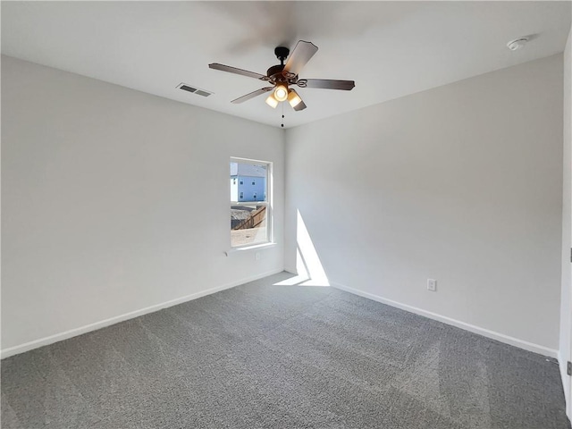 carpeted empty room with visible vents, a ceiling fan, and baseboards