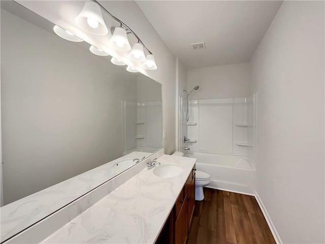 bathroom with visible vents, toilet, wood finished floors,  shower combination, and vanity