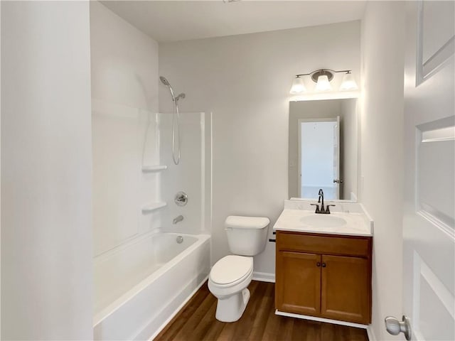 full bath featuring toilet, wood finished floors, shower / bathing tub combination, baseboards, and vanity