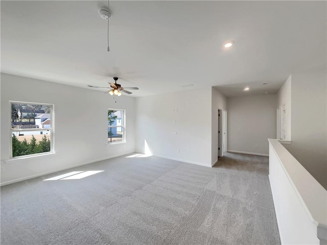 spare room with recessed lighting, light colored carpet, a ceiling fan, and baseboards