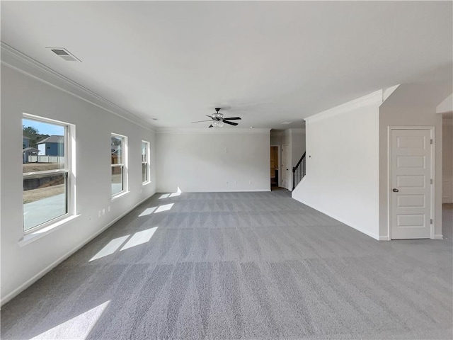 empty room featuring baseboards, visible vents, ornamental molding, stairs, and carpet flooring