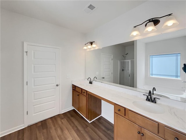 full bath featuring a shower stall, double vanity, visible vents, and a sink