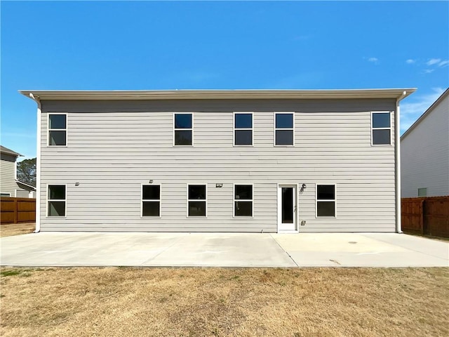 rear view of house with a yard, fence, and a patio area