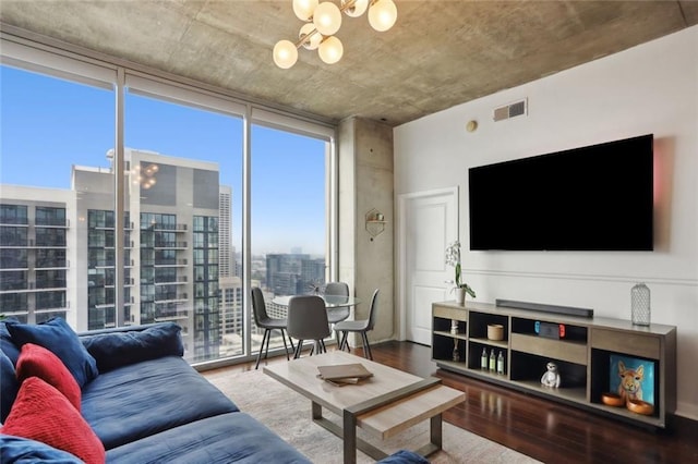 living area with a chandelier, a wall of windows, and wood finished floors