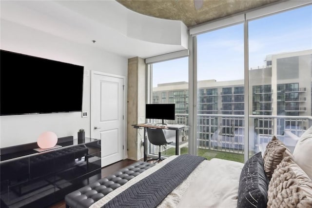 bedroom featuring expansive windows and wood finished floors