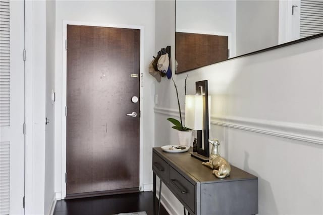 entryway with dark wood-type flooring and baseboards