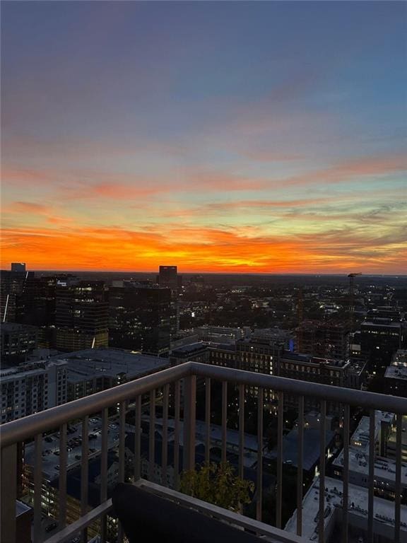 balcony at dusk featuring a view of city