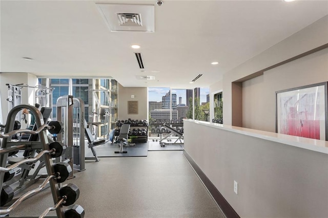 exercise room with expansive windows, a city view, and recessed lighting