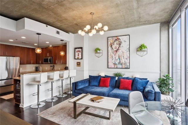 living room featuring dark wood-style flooring and a chandelier
