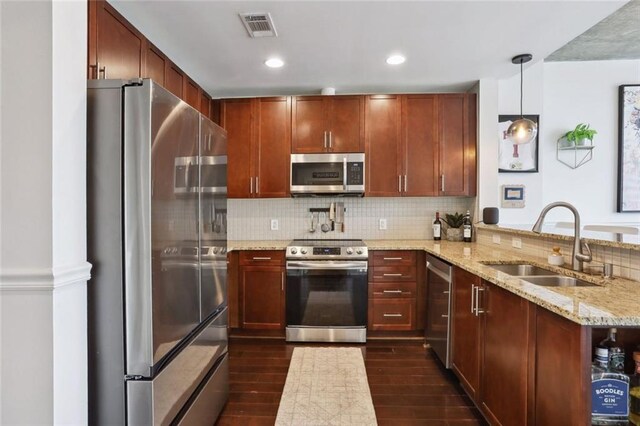 kitchen with stainless steel appliances, a sink, a peninsula, decorative backsplash, and dark wood-style flooring
