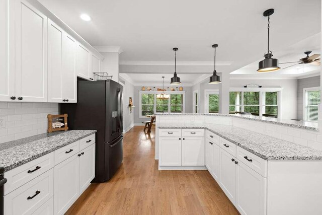 kitchen with white cabinetry, plenty of natural light, pendant lighting, and light hardwood / wood-style flooring