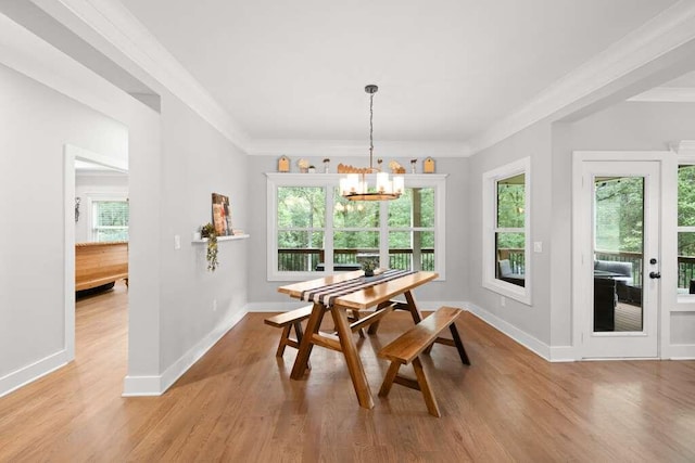 dining area featuring an inviting chandelier, plenty of natural light, light hardwood / wood-style flooring, and ornamental molding