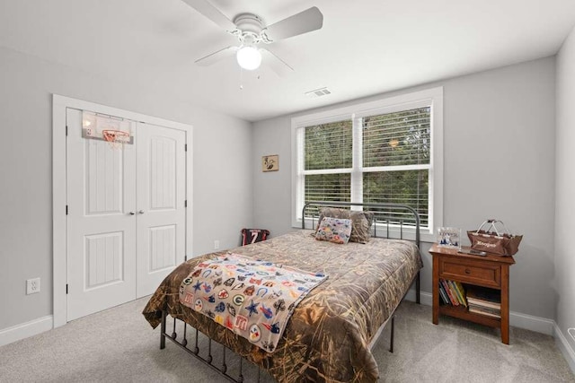 bedroom with a closet, light carpet, and ceiling fan