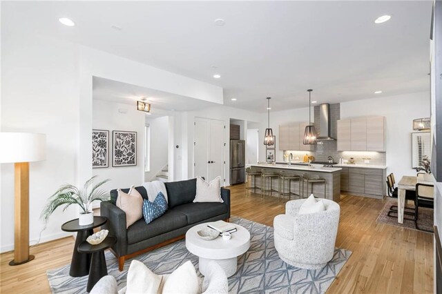 living room featuring light wood-style floors, stairway, and recessed lighting