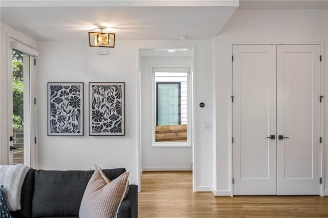 living area featuring baseboards and light wood finished floors