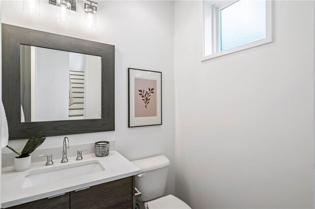 half bathroom featuring toilet and vanity