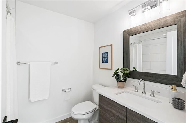 bathroom featuring vanity, baseboards, and toilet