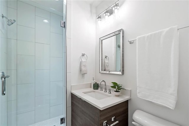 bathroom with vanity, a stall shower, and toilet