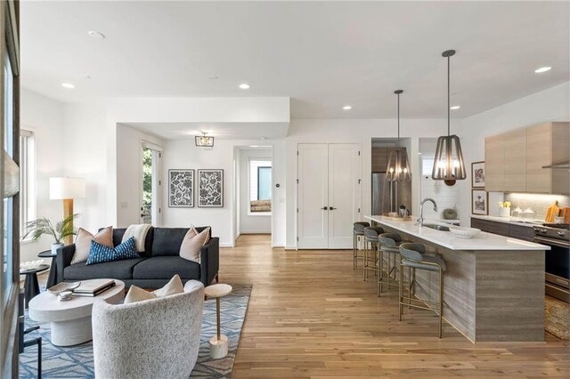 living area with light wood-type flooring and recessed lighting