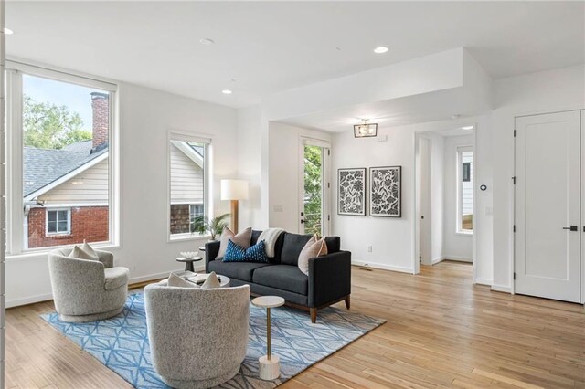 living area featuring recessed lighting, baseboards, and light wood-style floors