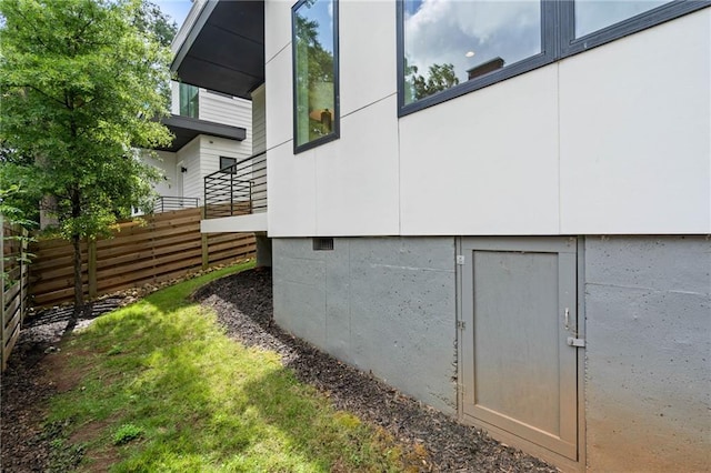 view of home's exterior featuring crawl space and fence