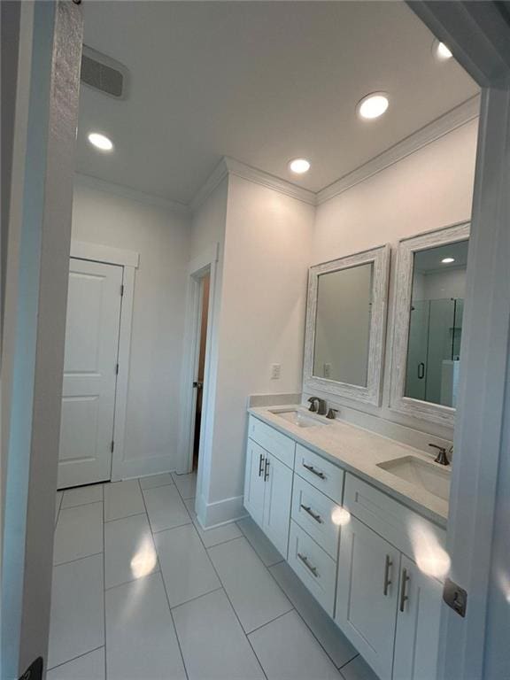 bathroom with vanity, crown molding, a shower with shower door, and tile patterned flooring