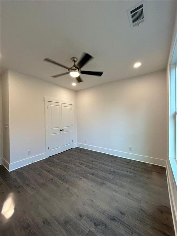 spare room with dark hardwood / wood-style floors and ceiling fan