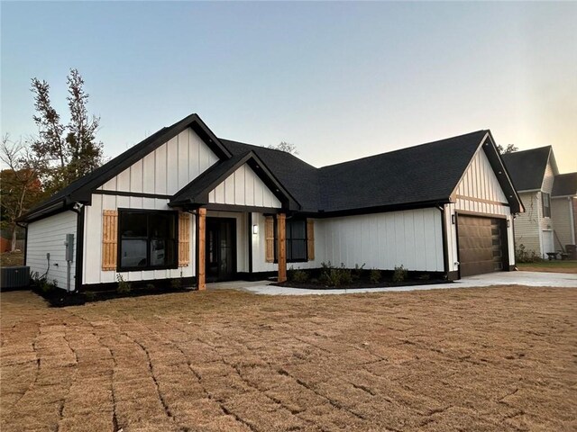 modern farmhouse style home featuring central AC and a garage