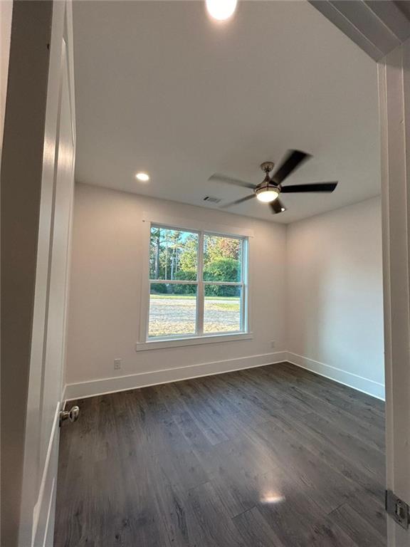 spare room featuring dark hardwood / wood-style floors and ceiling fan