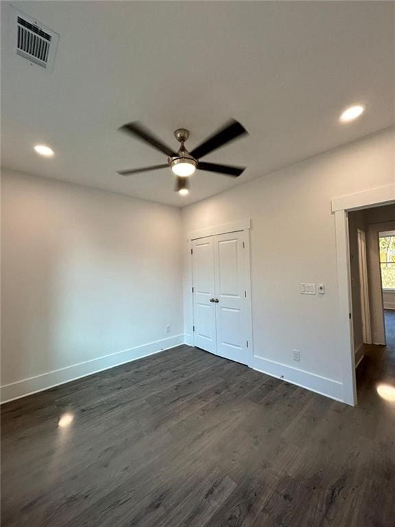 unfurnished bedroom with dark wood-type flooring, a closet, and ceiling fan