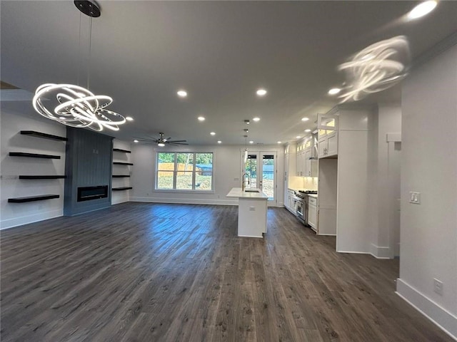 unfurnished living room featuring sink, ceiling fan, and dark hardwood / wood-style flooring