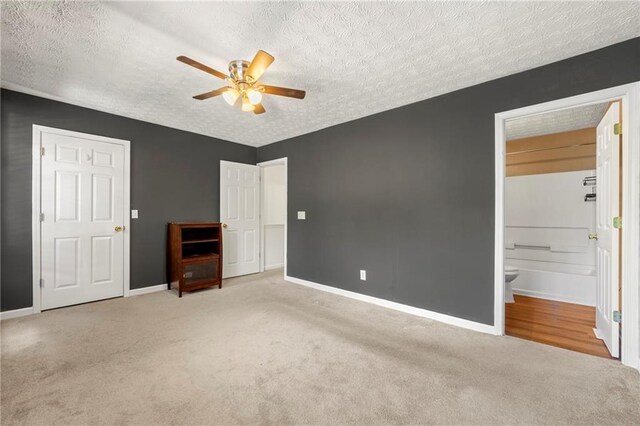 1382 Hollenbeck Ln, Riverdale, GA 30296 - unfurnished bedroom featuring carpet, a textured ceiling, connected bathroom, and a ceiling fan