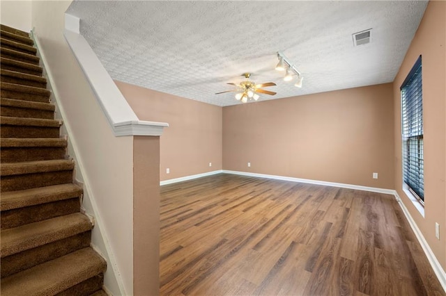 1382 Hollenbeck Ln, Riverdale, GA 30296 - spare room featuring wood finished floors, ceiling fan, stairs, track lighting, and a textured ceiling