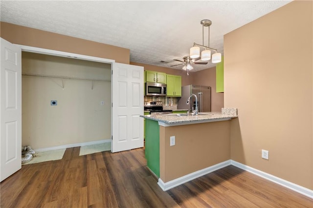1382 Hollenbeck Ln, Riverdale, GA 30296 - kitchen with appliances with stainless steel finishes, green cabinets, dark wood-style floors, and a peninsula