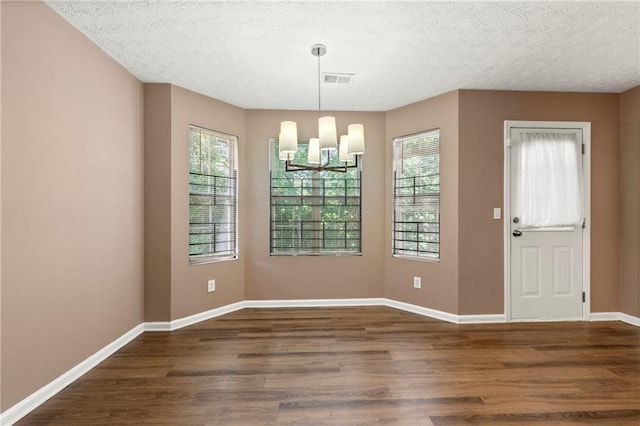 1382 Hollenbeck Ln, Riverdale, GA 30296 - unfurnished dining area with a chandelier, wood finished floors, and a textured ceiling