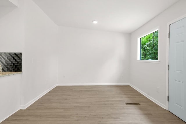 spare room featuring baseboards, recessed lighting, wood finished floors, and visible vents