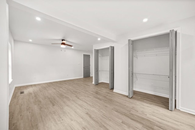 unfurnished bedroom featuring recessed lighting, light wood-style flooring, multiple closets, and baseboards