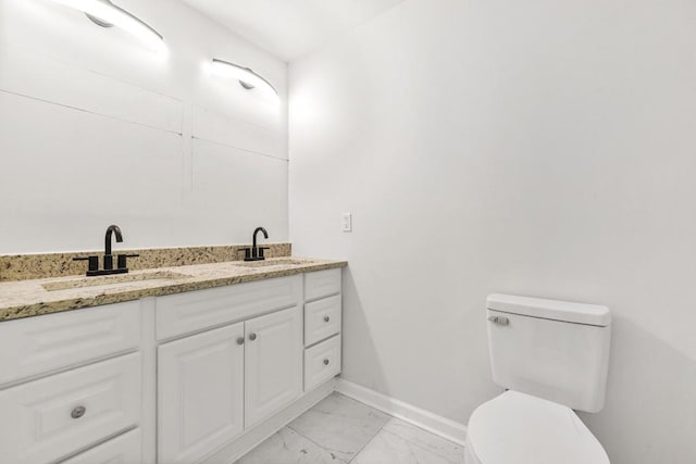 bathroom featuring baseboards, a sink, marble finish floor, and toilet