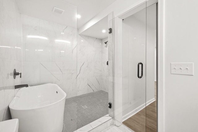 full bath featuring a freestanding tub, visible vents, and a stall shower