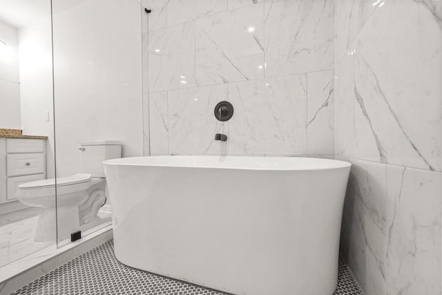 bathroom featuring tile walls, walk in shower, vanity, toilet, and a soaking tub