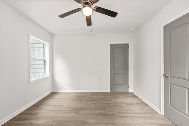 empty room featuring baseboards, a ceiling fan, and wood finished floors