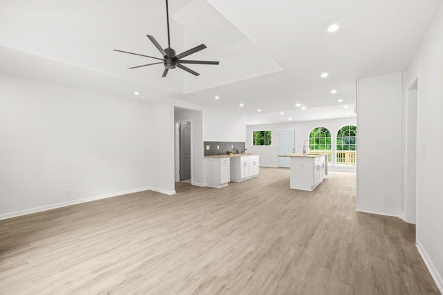unfurnished living room featuring recessed lighting, baseboards, ceiling fan, and light wood-type flooring