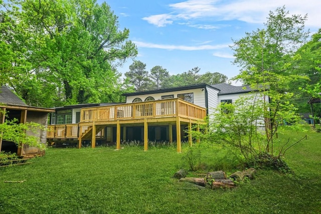 rear view of property with stairs, a wooden deck, and a yard