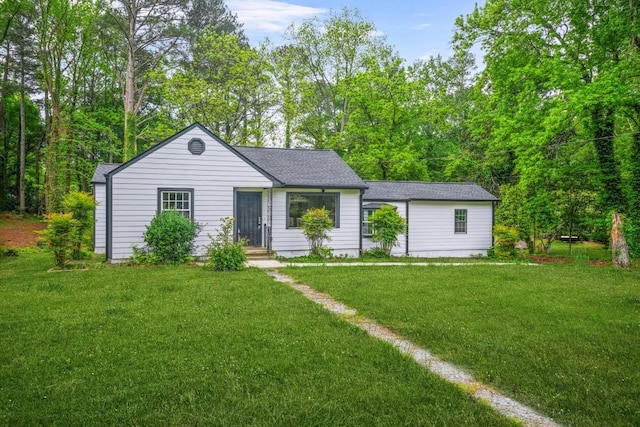 view of front of house with a shingled roof and a front yard