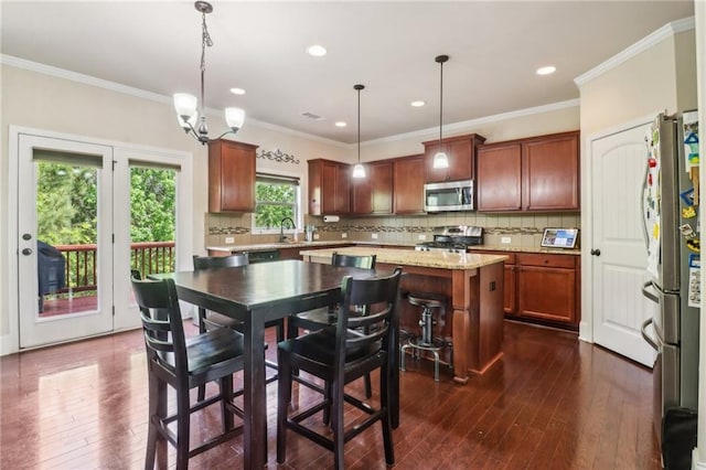 kitchen featuring dark wood-style flooring, backsplash, a kitchen island, and stainless steel appliances