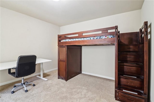 bedroom featuring light colored carpet and baseboards
