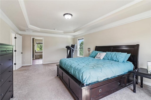 bedroom with crown molding, light colored carpet, a raised ceiling, baseboards, and ensuite bathroom