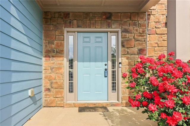 entrance to property featuring brick siding