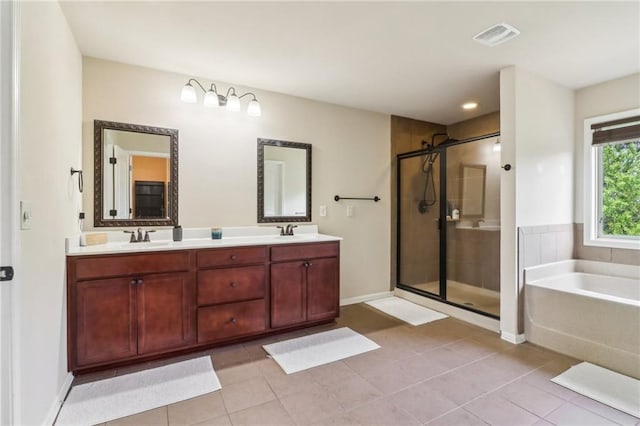 bathroom featuring visible vents, a sink, a bath, and a stall shower